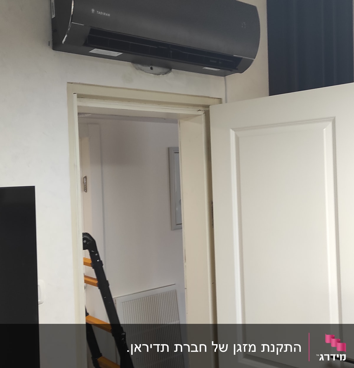 מזגן מותקן על קיר מעל דלת פתוחה